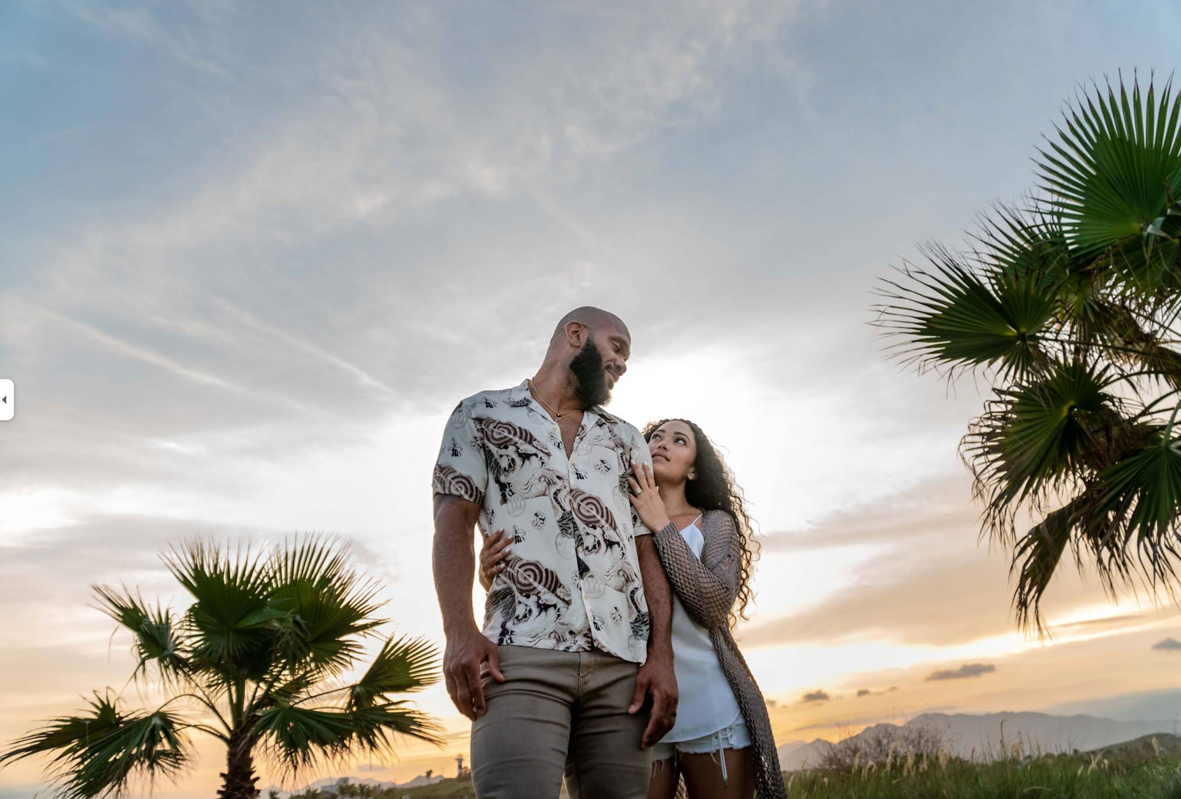 Couple photo session in Cabo San Lucas at sunset with palm trees and ocean views.